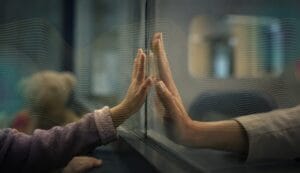 Betty Aldworth - Mothers Day - Betty Aldworth - Child reaches for mothers hand on the other side of a glass wall.